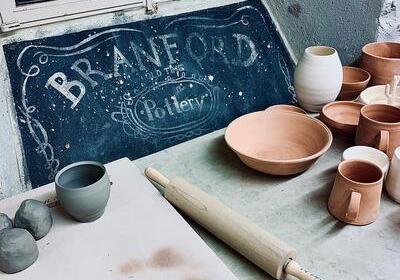 pieces of pottery surround a blue Branford sign