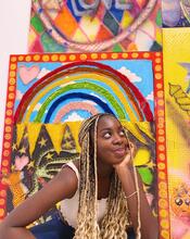 Photo of Simi Fagbemi smiling in front of a bright background.