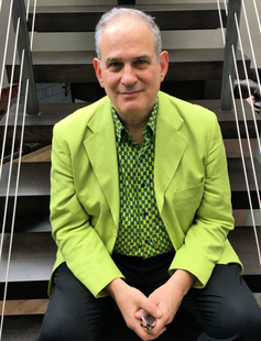 Steve Sandberg sitting on a staircase in a lime green jacket.